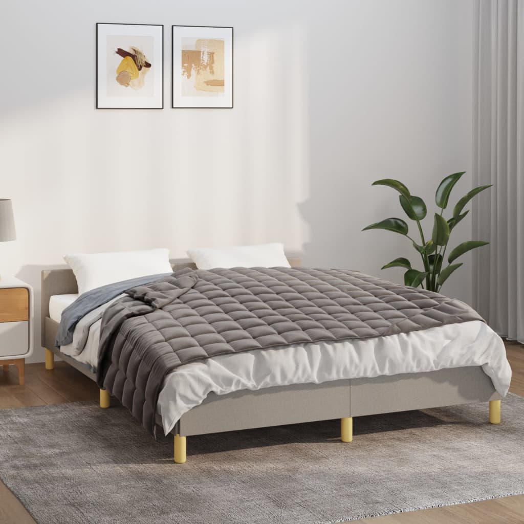 Grey weighted blanket on a bed, showing quilted texture and soothing deep-pressure design for better sleep and anxiety relief.