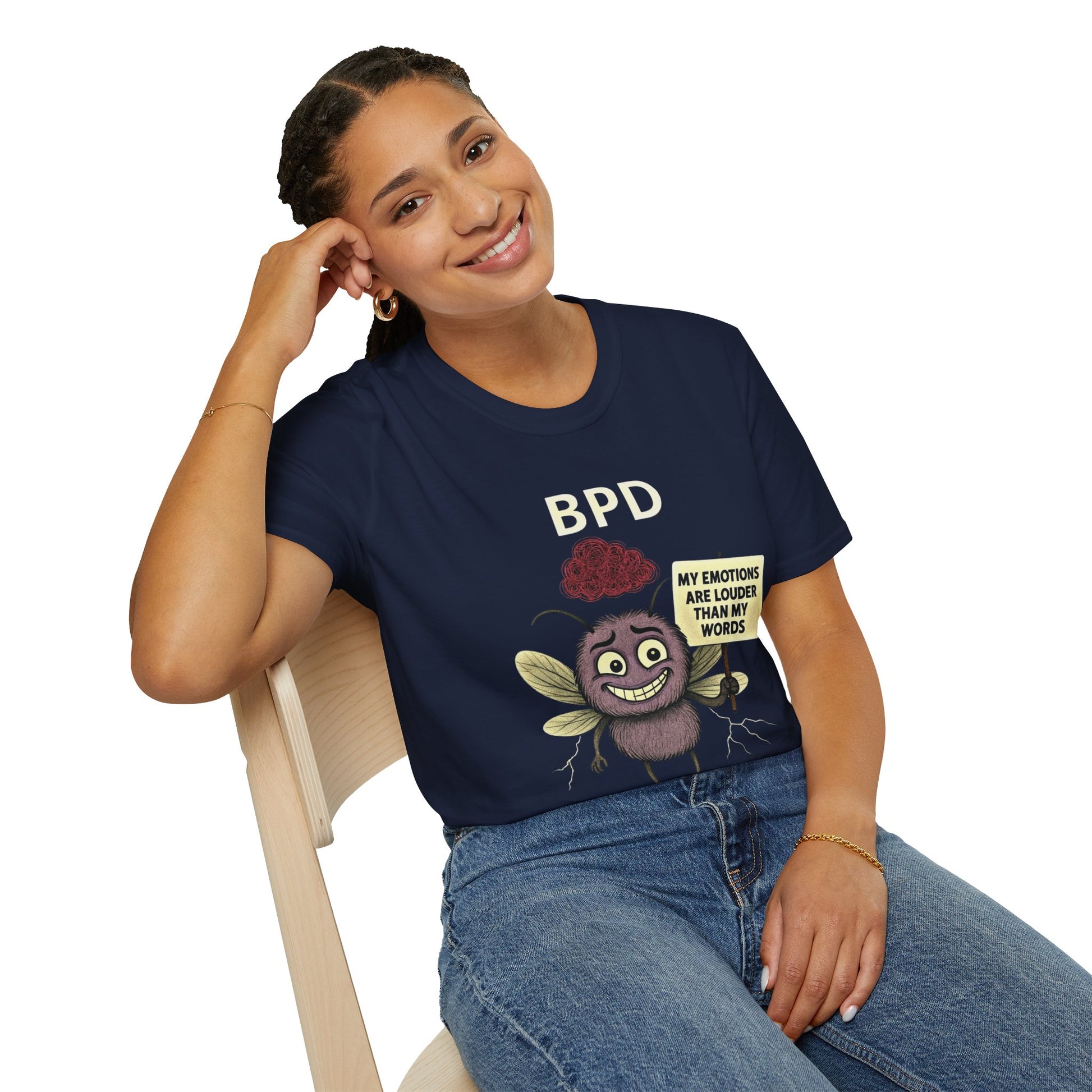 Person wearing a navy blue t-shirt with a graphic design and text, sitting on a white background