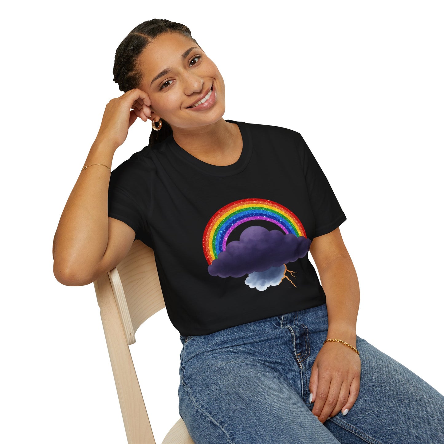 Person wearing a black t-shirt with a rainbow and Tempest cloud design, sitting on a chair.