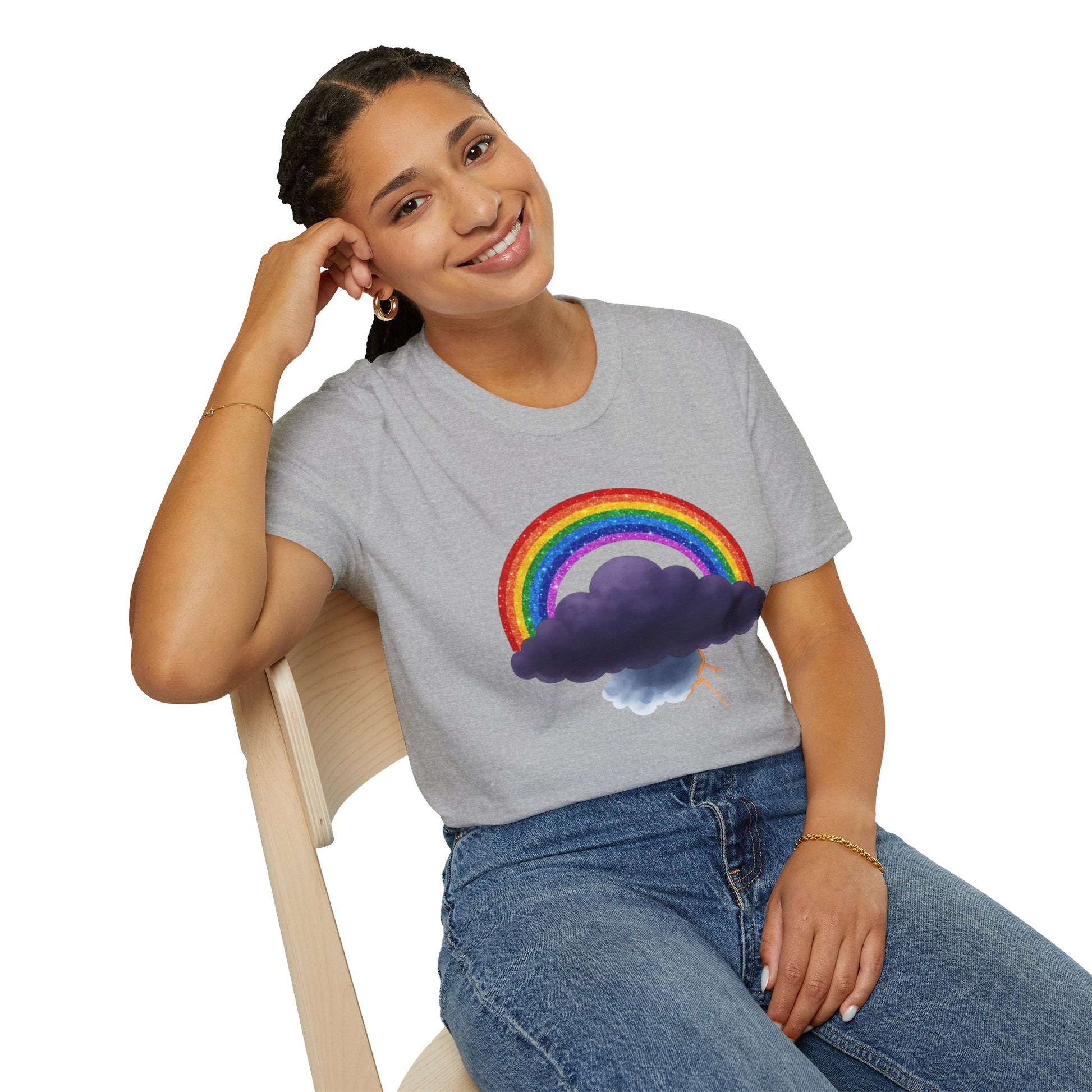 Person wearing a gray t-shirt with a rainbow and Tempest cloud design, sitting on a chair.